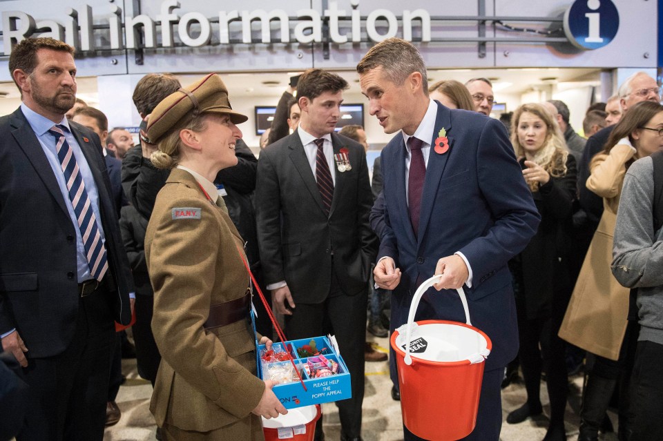 Gavin Williamson (centre right) talks to a poppy seller at Waterloo Station earlier this evening