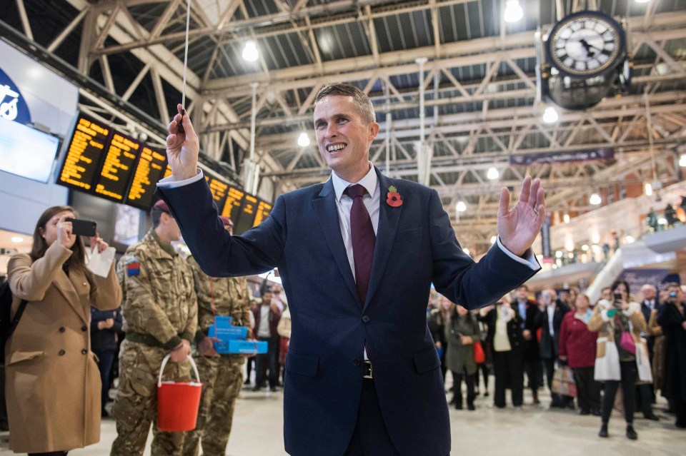 New Secretary of State for Defence Gavin Williamson conducts the Band of the Grenadier Guards at Waterloo Station in London