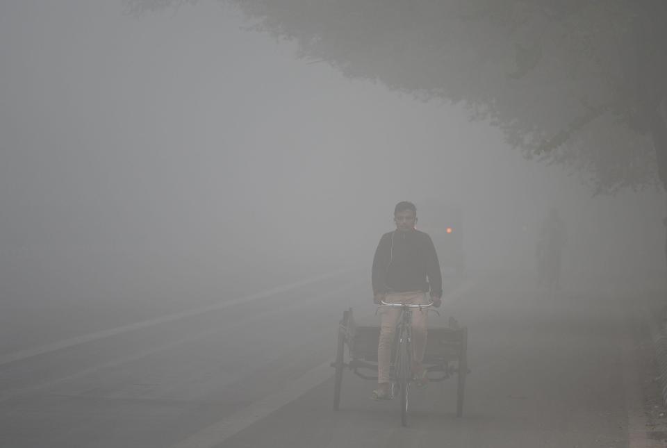  A man bikes through the dense New Delhi smog