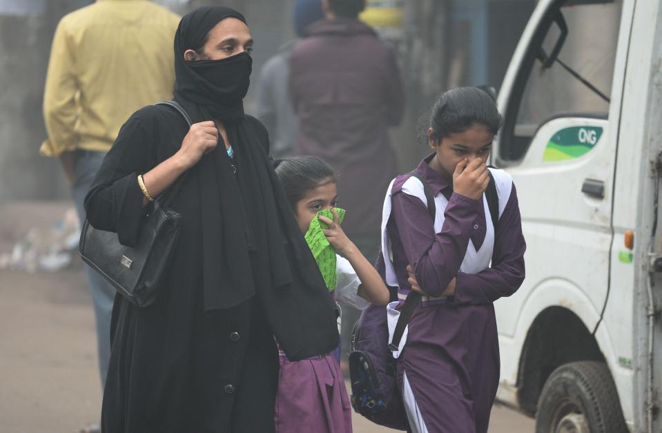  Residents make their way through the city while covering their faces