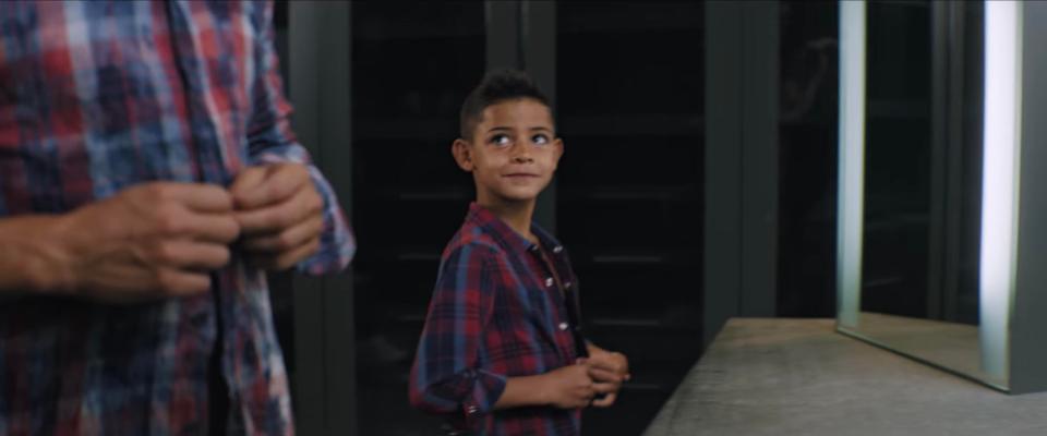  The youngster stares up at his father while wearing a new shirt from the collection