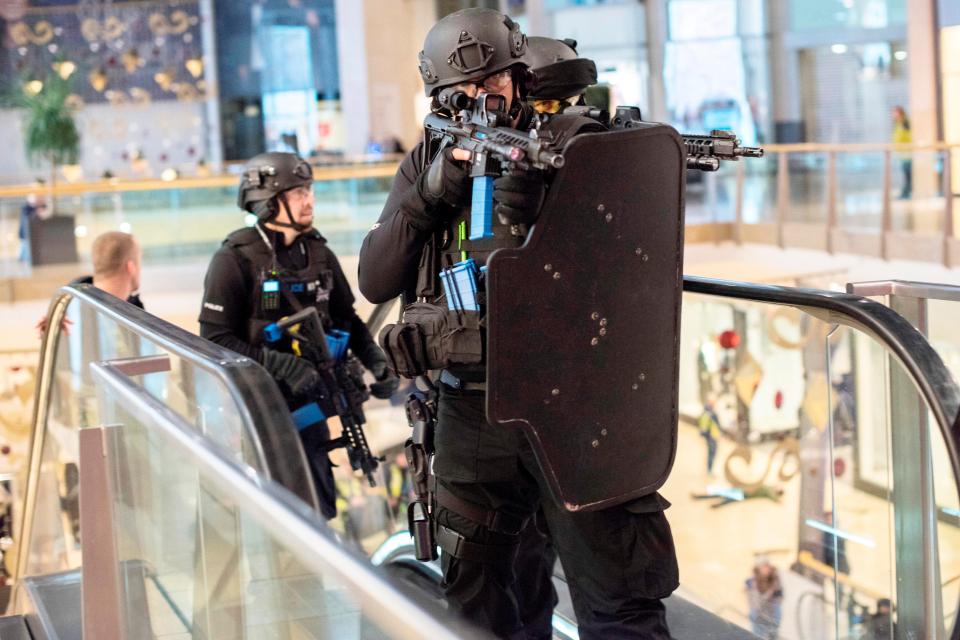  Officers with automatic rifles and bullet-proof shields take up positions on the escalators in the simulated terror attack