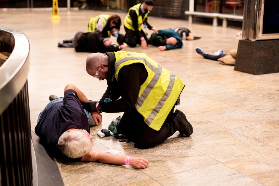  Volunteers playing injured victims lie strewn across the floor of the shopping centre