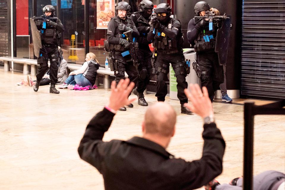  A shopper holds up in hands as armed cops storm the Bullring centre in Birmingham last night