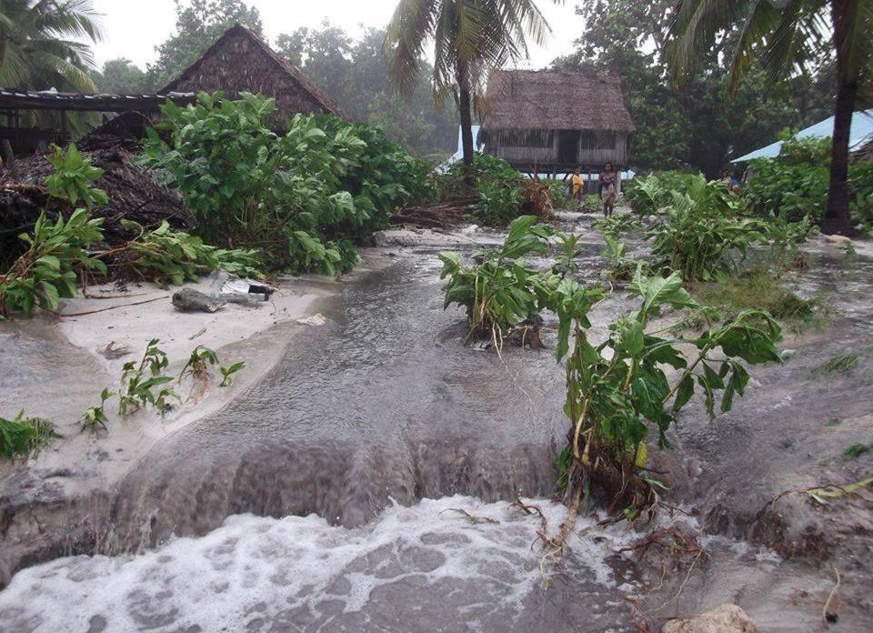  Flood waters gush through a village in Kiribati during Cyclone Pam in 2015