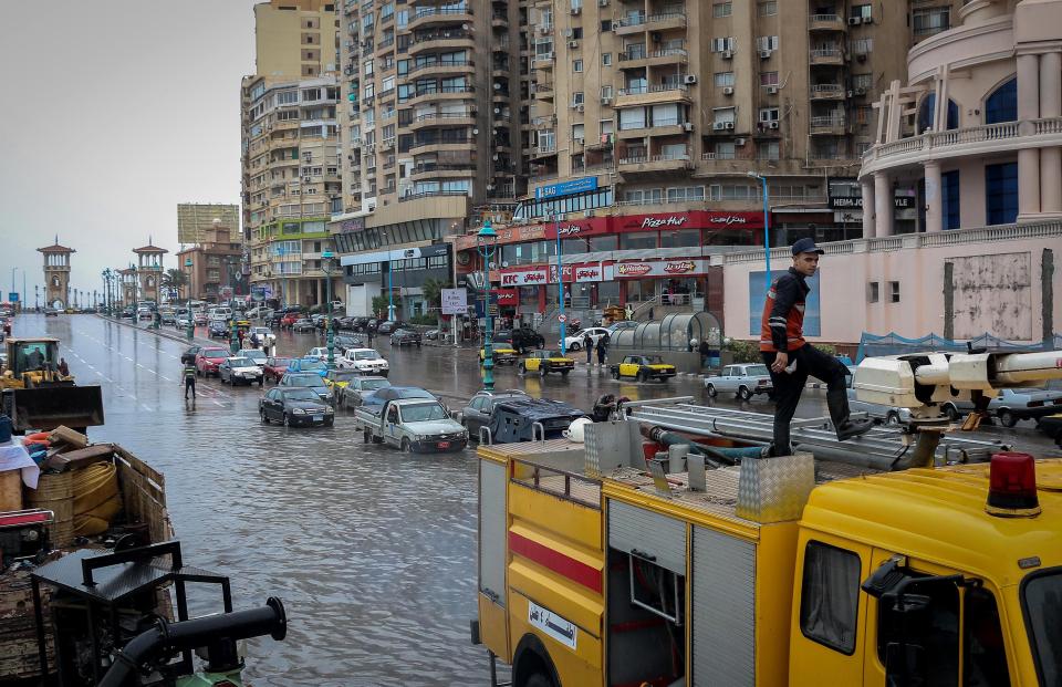  A fire crew try to pump water from the road in Alexandria, Egypt, in 2015