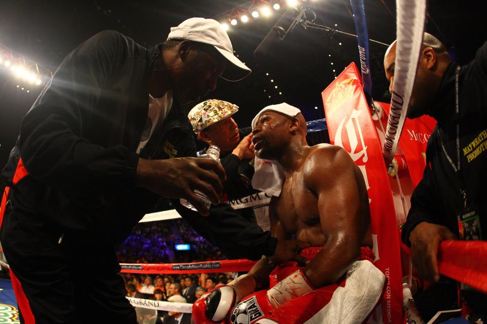  Roger Mayweather talks as cut man Rafael Garcia works on Mayweather's nose against Miguel Cotto in 2012