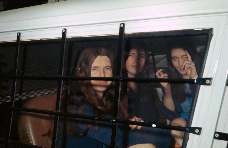 Cult members Patricia Krenwinkle, left, Leslie Van Houten, centre and Susan Atkins, right, smile from inside a police van during their trial