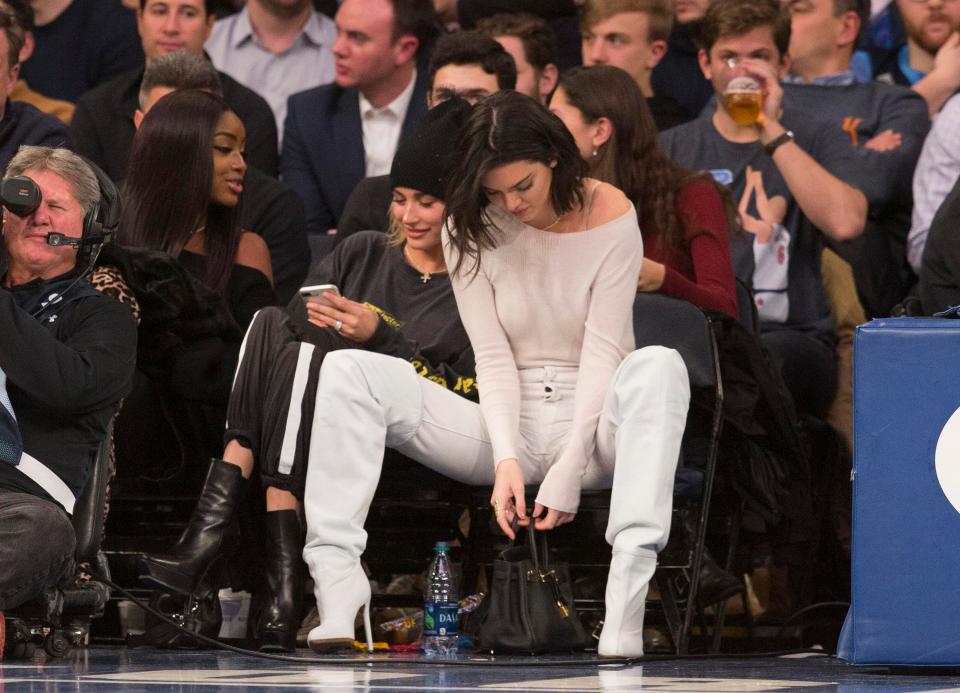  Kendall fiddled with her designer handbag while Hailey concentrated on her phone