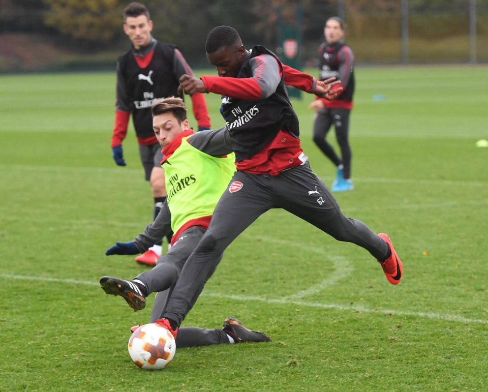  Mesut Ozil lunges in on youngster Eddie Nketiah in training