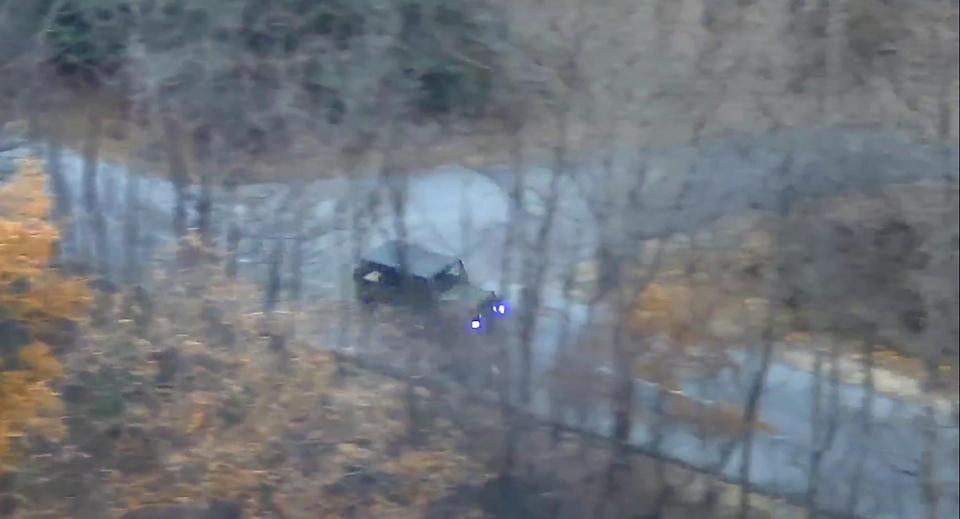  He motors down a tree-lined road in a North Korean army jeep