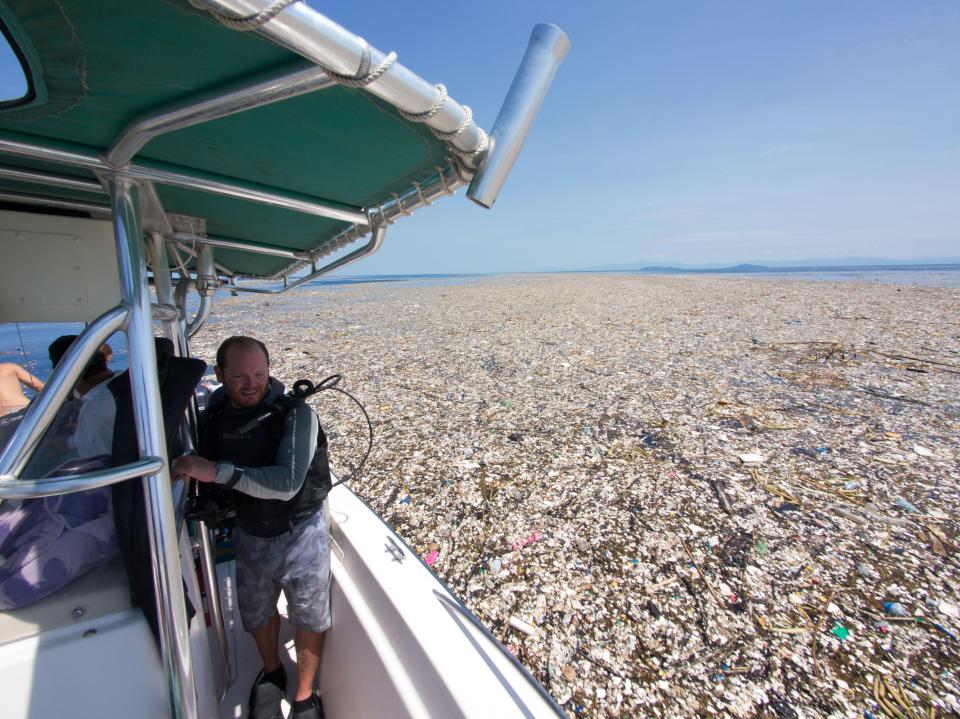  A boat can be seen cruising through an epic 'rubbish island' off the coast of Roatan, Honduras