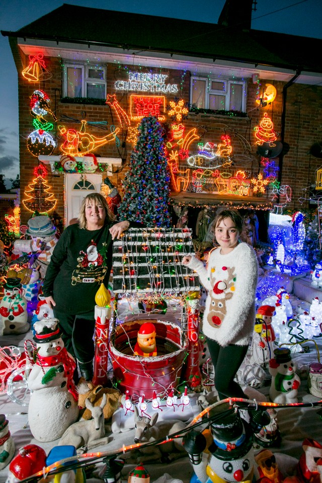 Mother and daughter proudly pose in front of their Christmas display