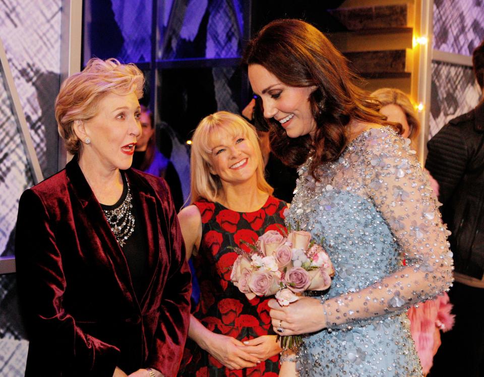  The Duchess of Cambridge clutched pink flowers to her stomach as she spoke to performers