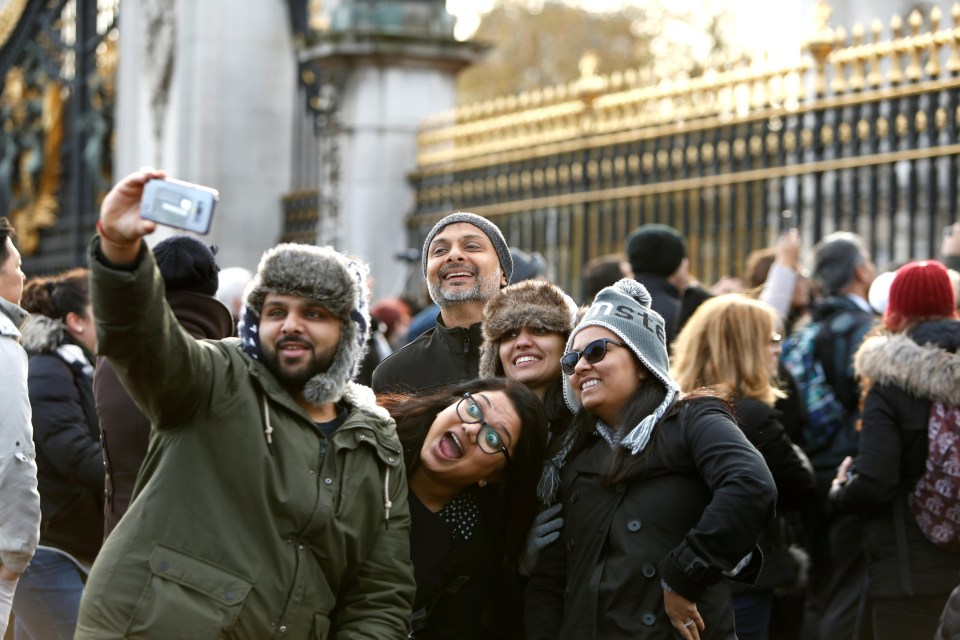 Prince Harry fans stand outside Buckingham Palace after his engagement was announced today