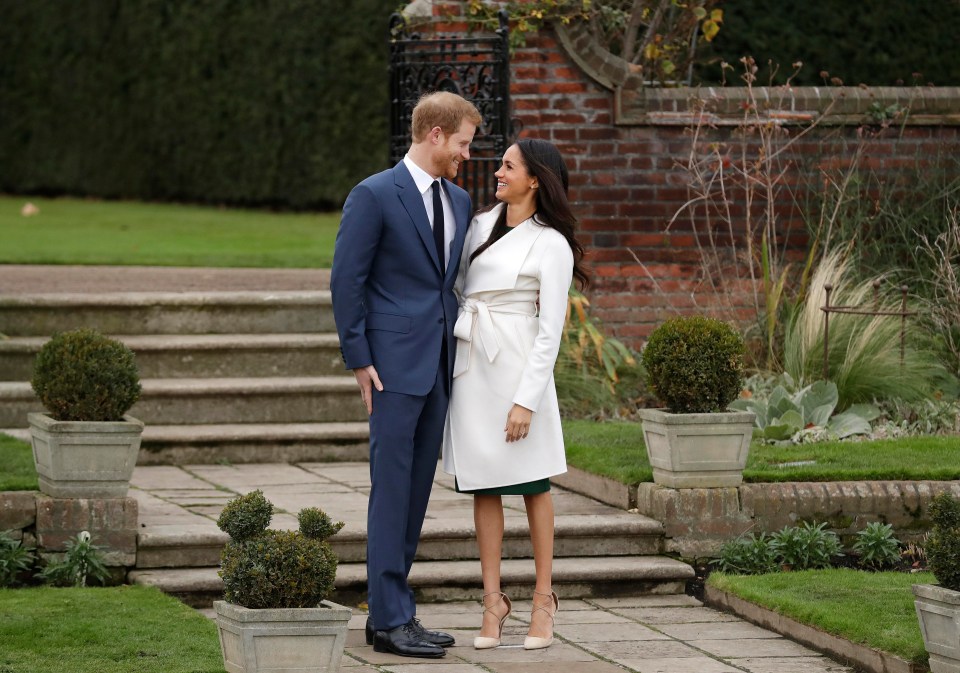 The newly engaged couple stood by the steps of the Sunken Garden as they were snapped by photographers