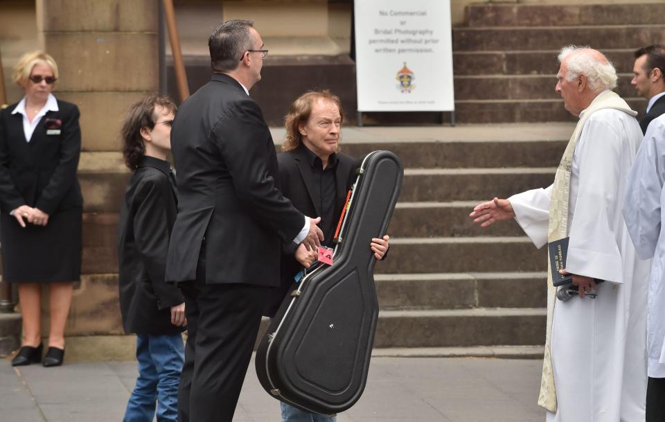  Malcolm's brother Angus carries the guitar to sit with his coffin in the hearse