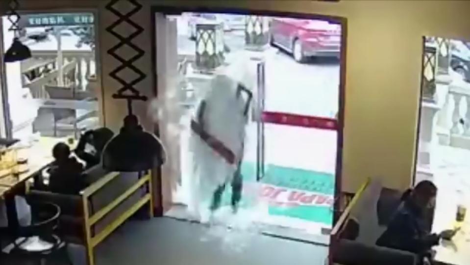  Rushing takeaway driver vanishes behind a waterfall of glass as he walks head-first through a restaurant door