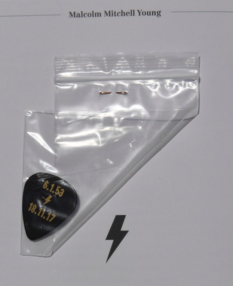  Guitar picks engraved with Malcolm's birth and death dates were handed out to the congregation, pinned to the order of service