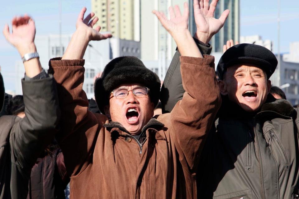  North Koreans cheers as they watch Kim order the firing of the missile