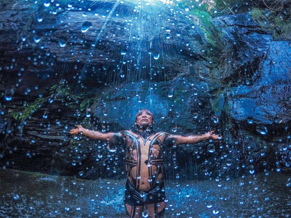  A Yawalapiti indian stands underneath a waterfall in Chapada dos Veadeiros in an image that evokes memories of hit science fiction film Avatar