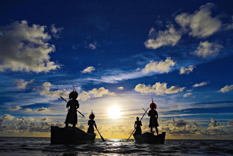  Pataxó Indians stand on their boats to watch the sunrise in the Porto Seguro, Bahia state