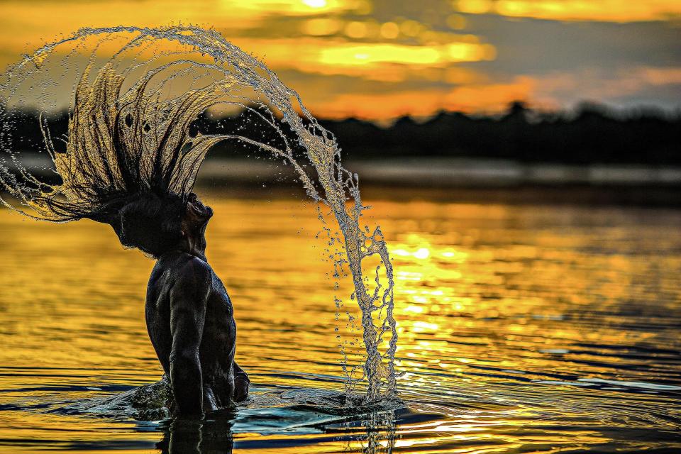  A Bejà Kayapó man washes himself in the Xingu River at sunset