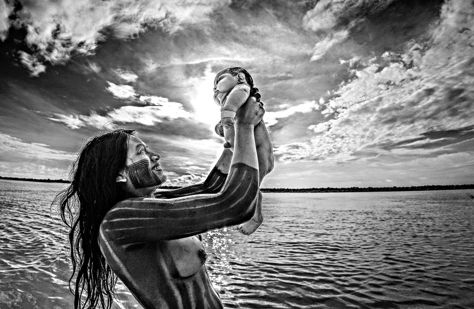  A Kayapó Indian woman washes her baby in the Xingu River, state of Mato Grosso