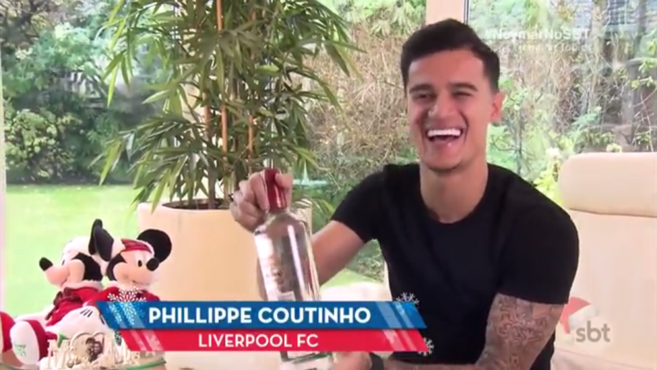  Philippe Coutinho is given a bottle of vodka from Luis Suarez for Christmas