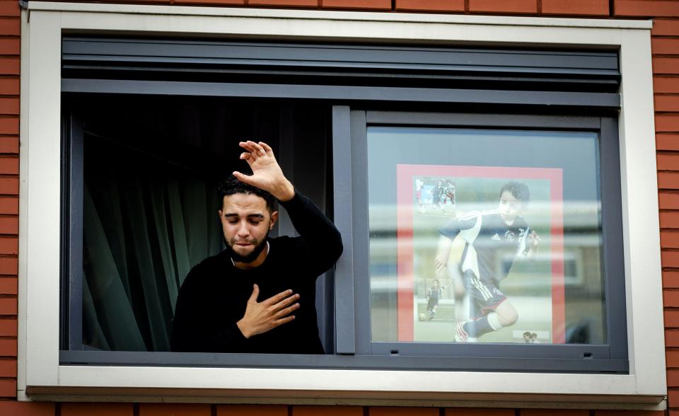  Brother of Dutch midfielder Abdelhak Nouri, Mohammed, thanks fans out of the window of the family home