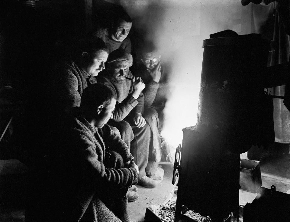  Crew members huddle around a fire during a night watch