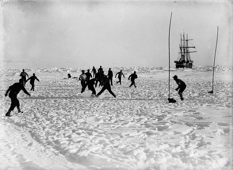  With the Endurance in the background crew members relieve the boredom with a game of football on the ice