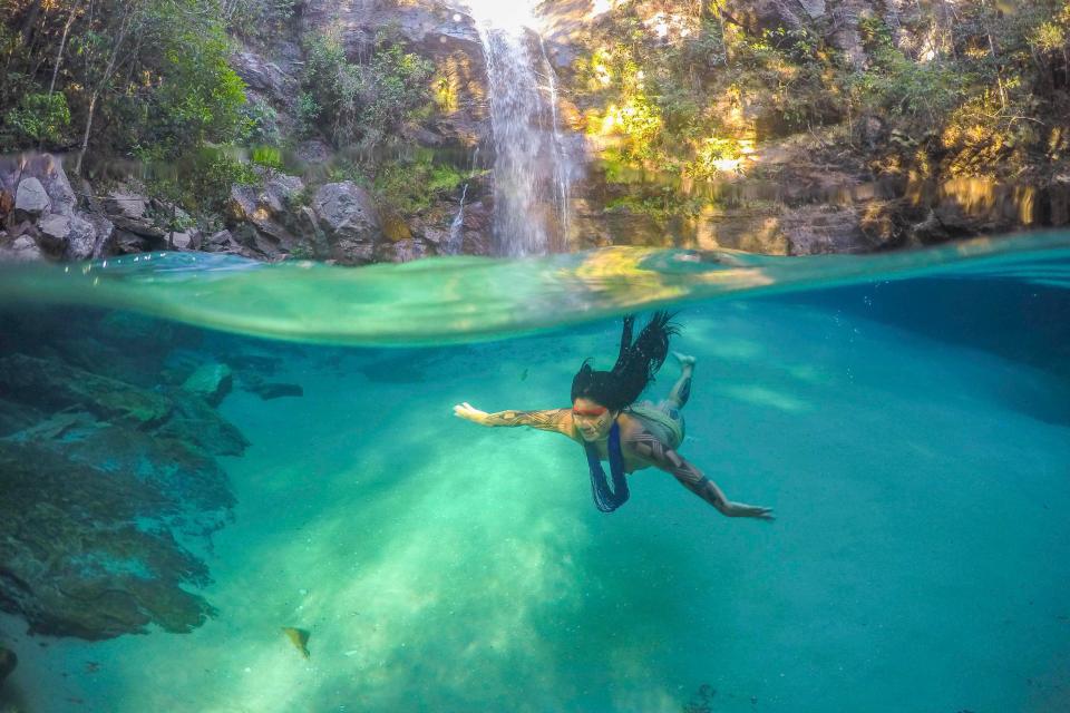  A tribeswoman from the Akuku Kamauyrá clan dives in the Santa Bárbara waterfall in Chapada dos Veadeiros, Brazil