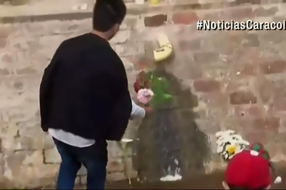 A man approaches the 'miracle' algae with a handful of flowers 