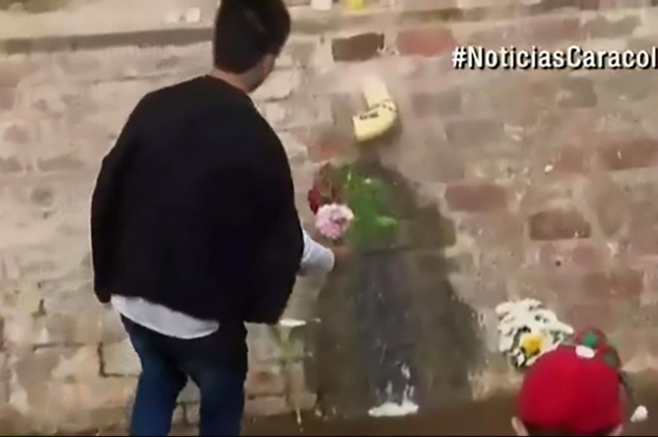  A man approaches the 'miracle' algae with a handful of flowers