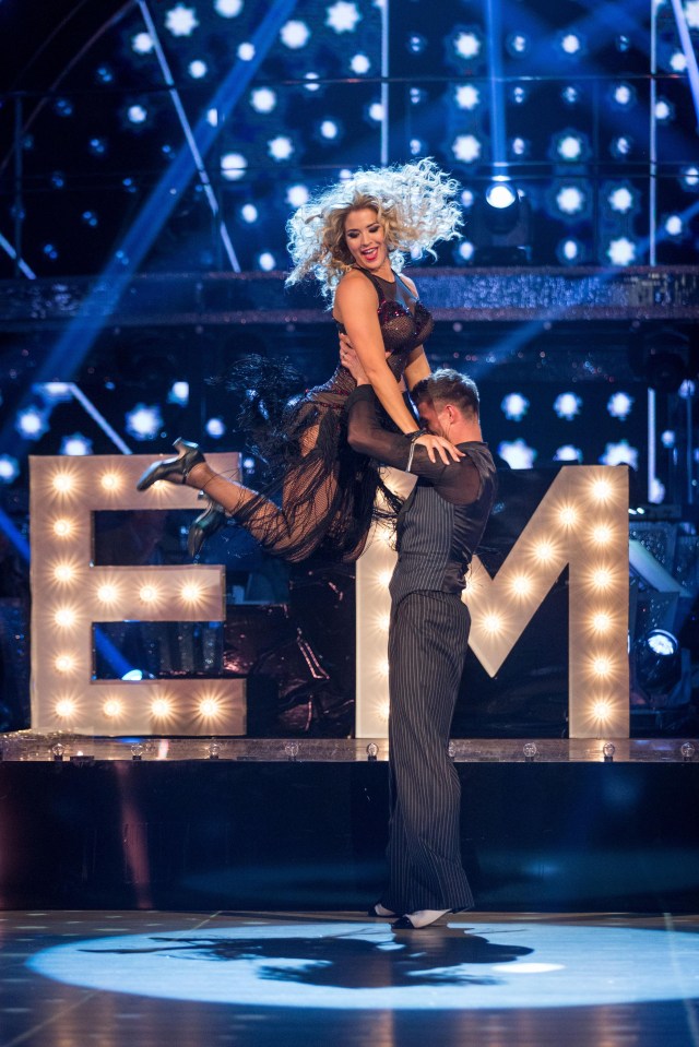 a woman is being lifted in the air by a man in front of a sign that says em