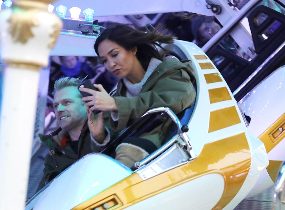  Myleene Klass risks dropping her phone as she takes a selfie on a theme park ride with her partner