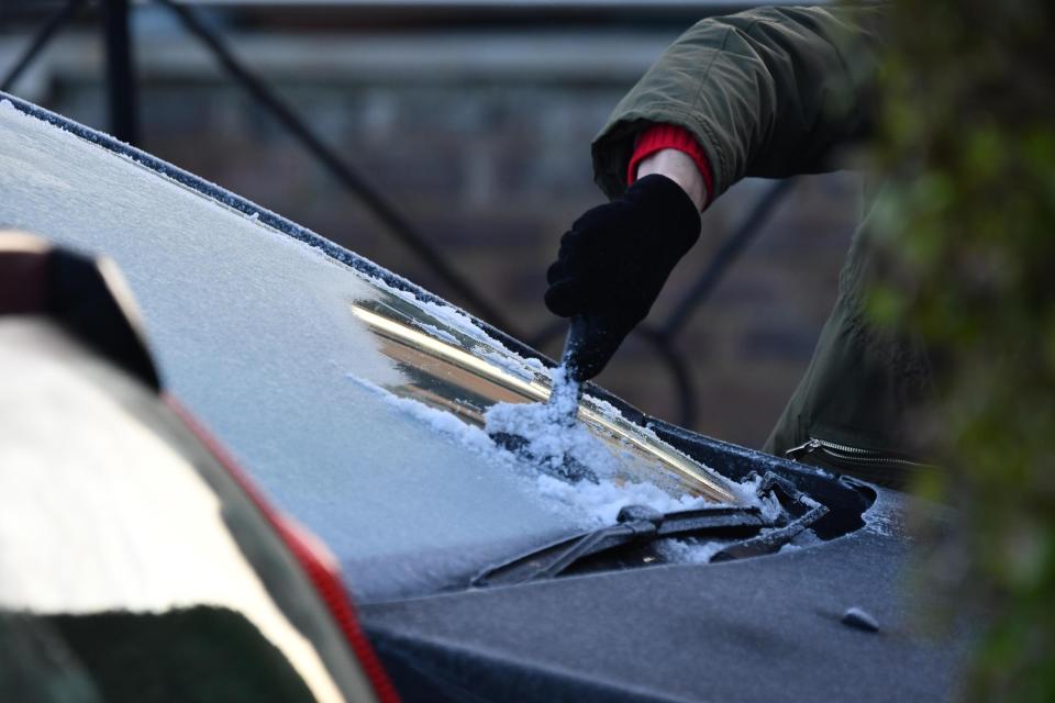  A woman scrapes off her icy windscreen in Littlehampton following freezing temperatures overnight