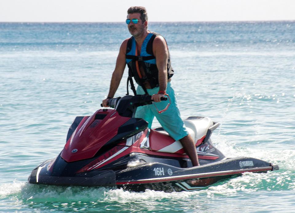  Simon Cowell perches on a jet ski as he kicks off his holiday with partner Lauren