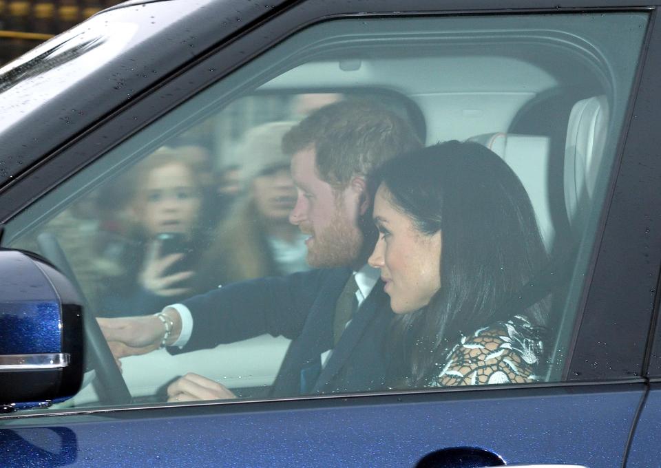  Meghan appeared to smile as she sat beside her fiance Prince Harry as they arrived for the family Christmas