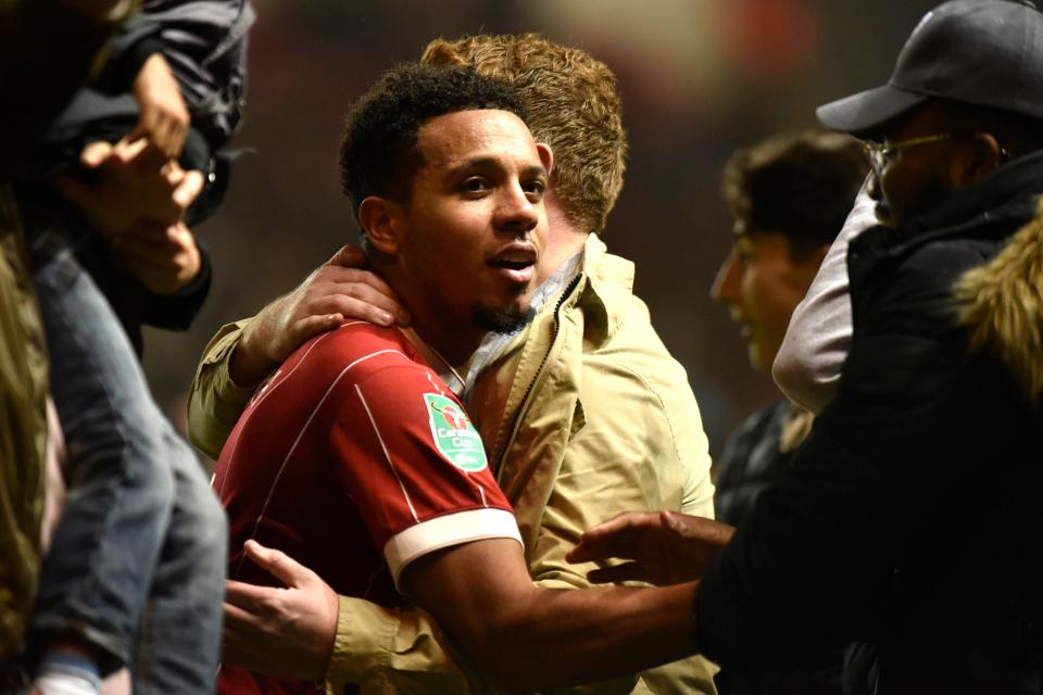  Korey Smith hugs Bristol City fans as he soaks up the celebrations on the pitch