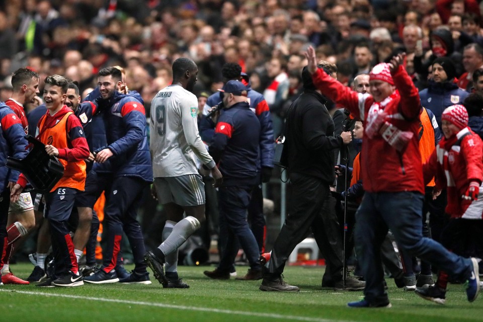 Manchester United striker Romelu Lukaku walks past Bristol City's celebrating fans