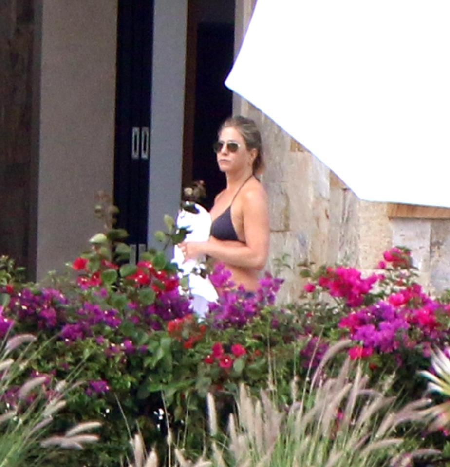  Jen clutches a white dressing gown for her balcony outing