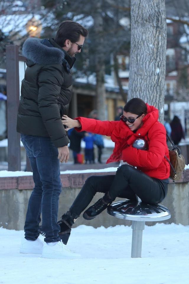  Sofia Richie laughs as her boyfriend Scott Disick plays with her on a playground seat