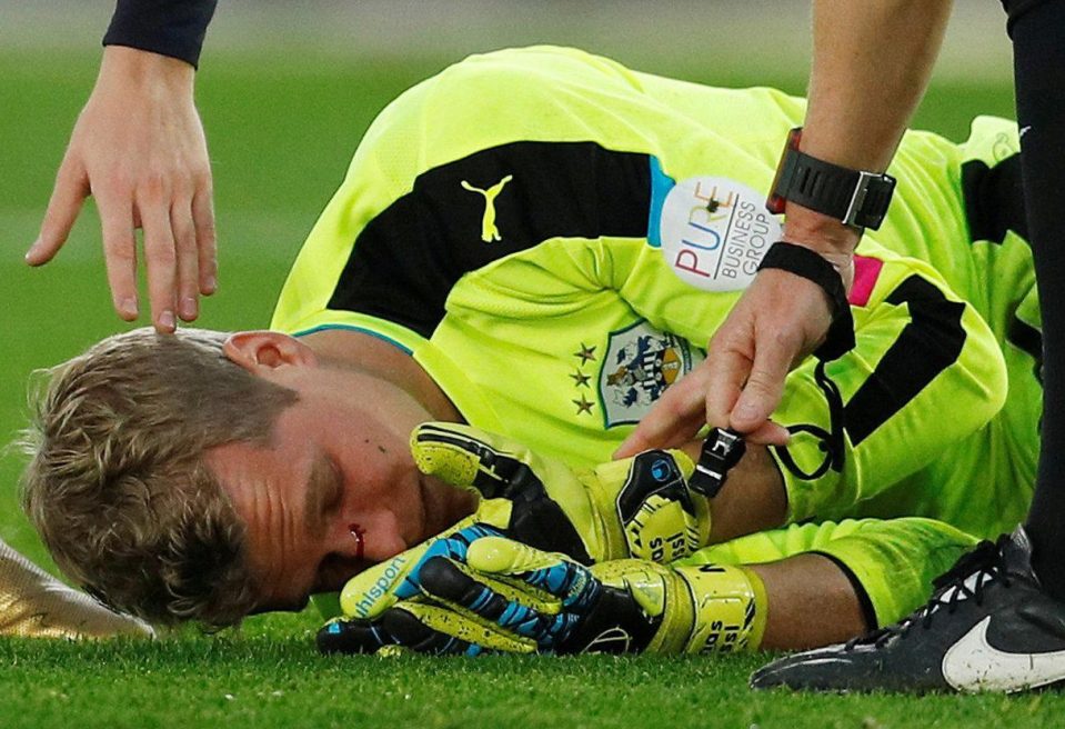  Jonas Lossl reels after his nose was broken in the challenge from Charlie Austin