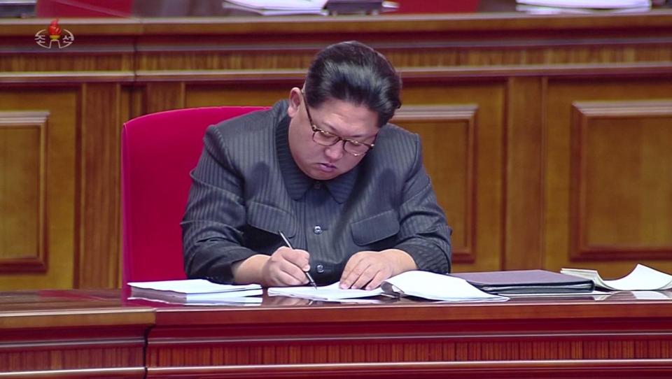  Kim Jong-un makes notes during the conference