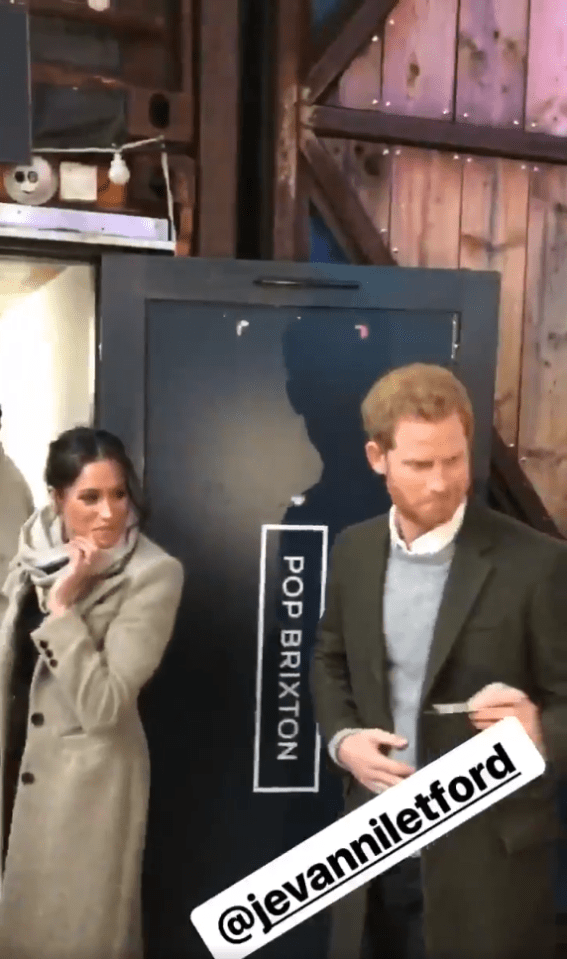  Prince Harry could be seen grabbing the business card, with Meghan looking on