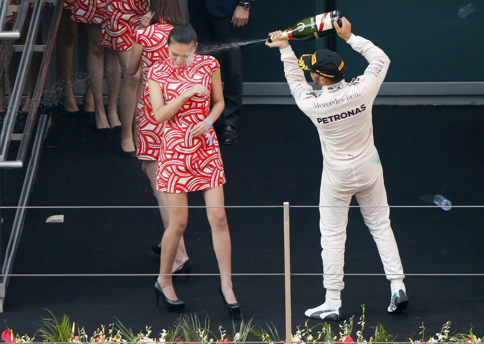 Lewis Hamilton drenches the pit girls in champagne on the podium