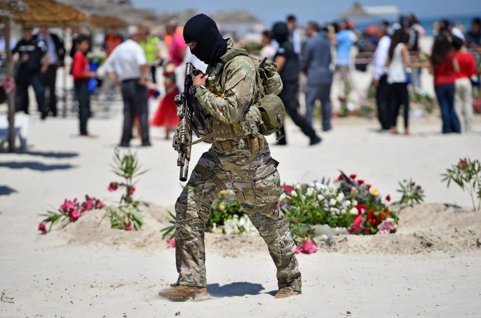 An armed cop patrols the beach at Sousse after the 2015 tourist atrocity