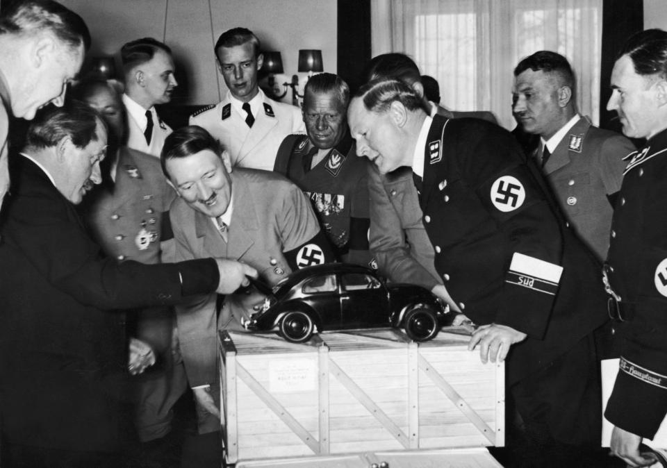  Adolf Hitler admires a model of the Volkswagen car along with the designer Ferdinand Porsche, left, pictured with his arm out stretched